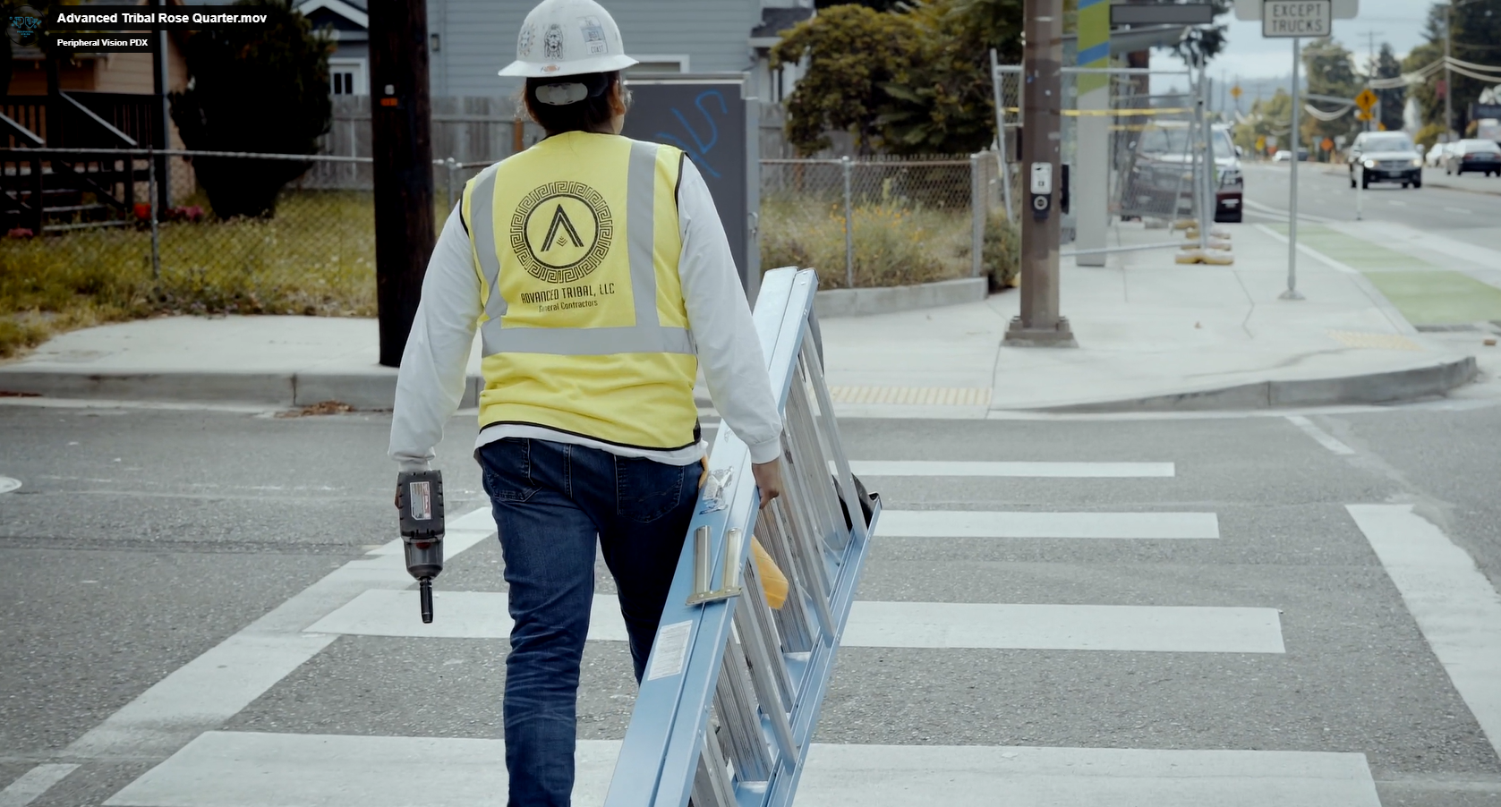 Advanced Tribal staff member heading to a worksite holding a ladder.