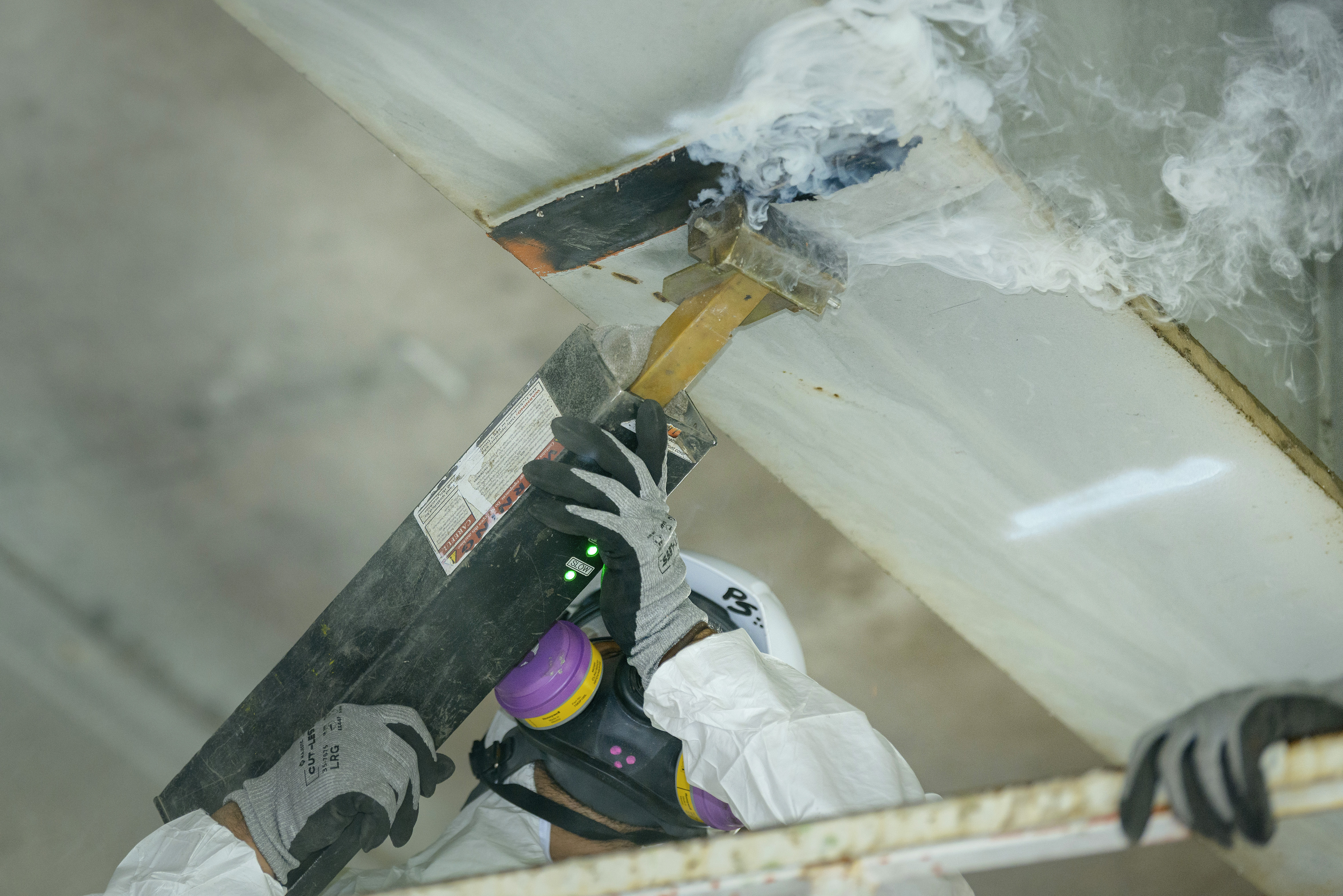 Crews remove lead paint on beams under I-5 to prepare for installation of bolts.